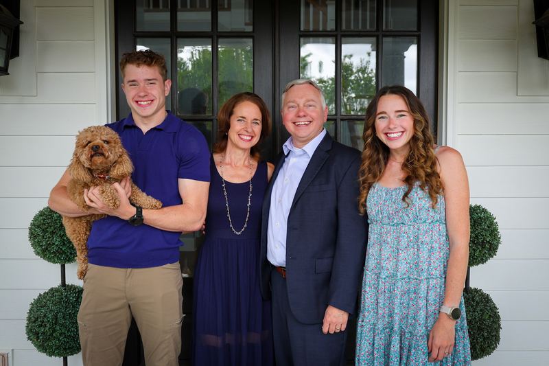 Family portrait on a front porch with the family dog
