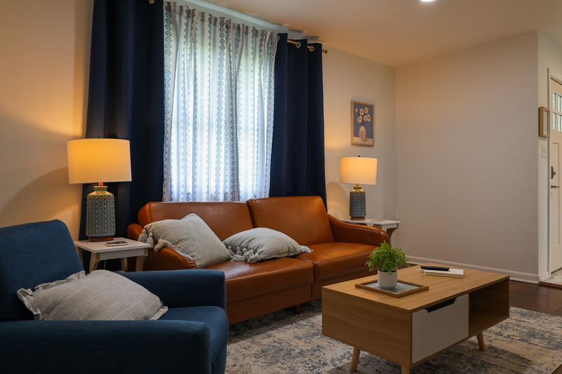 Bright living room with a leather sofa and table lamps